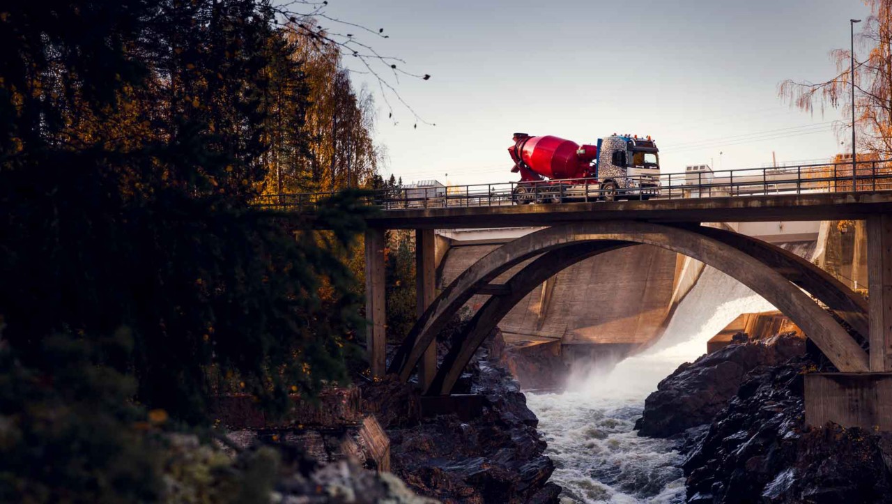 „Volvo FMX“ važiuoja tiltu per upę