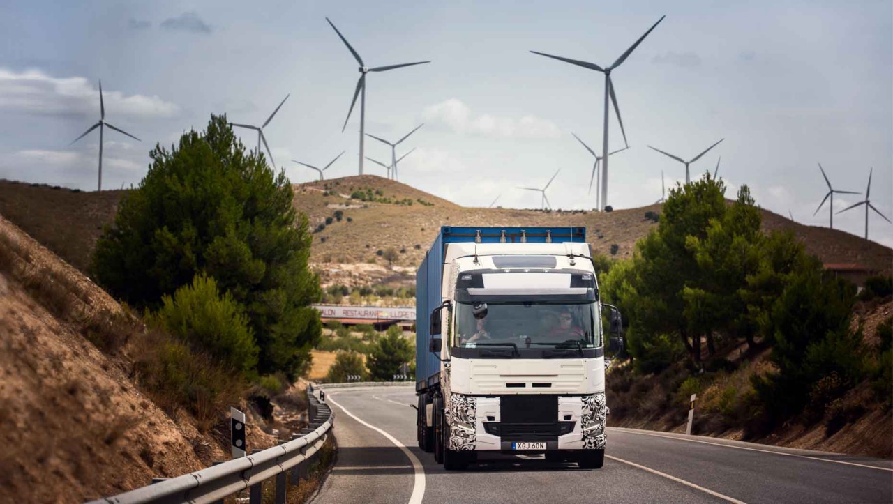 Bandomasis sunkvežimis kelyje Ispanijoje su vėjo turbinomis fone